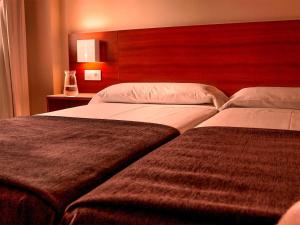 A bed or beds in a room at Apartamentos Vértice Bib Rambla