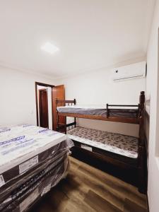 2 stapelbedden in een kamer met houten vloeren bij Cobertura - Quadra Mar in Itapema