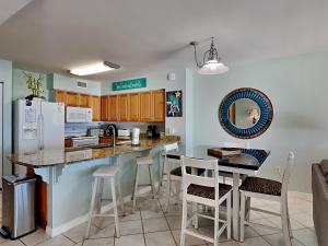 uma cozinha com um balcão e bancos num quarto em Island Princess #705 em Fort Walton Beach