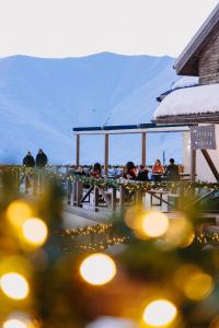 a group of people sitting at a table with lights at Alpina Hotel in Gudauri