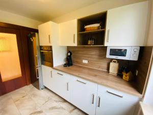 uma cozinha com armários brancos e um micro-ondas em Am Gallerturm mit Seeblick em Überlingen