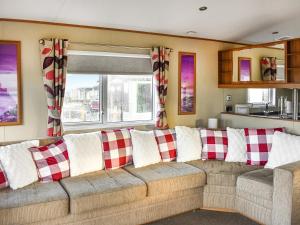 a living room with a couch with red and white pillows at Solway View in Plumbland