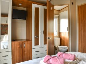 a bedroom with a toilet and a bed with pink pillows at Solway View in Plumbland