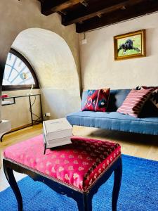 um quarto com um sofá e um banco com um livro em Ca' Degli Uberti Dimora Storica em Treviso