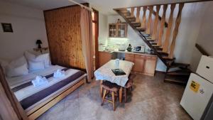 ein Schlafzimmer mit einem Bett, einem Tisch und einer Treppe in der Unterkunft Balla Apartmanház in Siófok