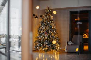 een kerstboom in de hoek van een kamer bij Alpina Hotel in Goedaoeri