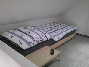 a bed in a room with a table next to it at Unseburg-Ferienwohnung 5 