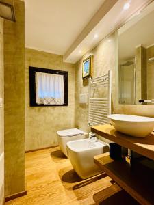 een badkamer met 2 wastafels en een toilet. bij Ca' Degli Uberti Dimora Storica in Treviso