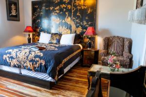 Un dormitorio con una cama, una silla y una mesa. en Oak Tree Hotel, en Arcadia