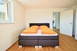 ein Schlafzimmer mit einem Bett mit orangefarbenen Kissen darauf in der Unterkunft La Terrazza in Überlingen
