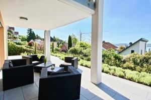 un patio al aire libre con sillas y mesas negras y vistas en La Terrazza en Überlingen