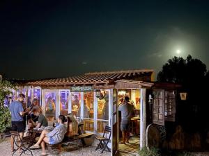 un grupo de personas de pie fuera de un edificio por la noche en Tiny House Eloá en Lourinhã