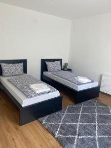 2 Betten in einem Zimmer mit einem Teppich in der Unterkunft ND Hotels & Apartment Superior Bottrop in Bottrop