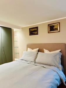 um quarto com uma cama com lençóis brancos e almofadas em Ca' Degli Uberti Dimora Storica em Treviso