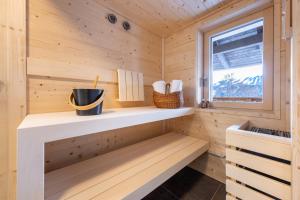 een houten sauna met een bank en een raam bij Appartements Uribi mit eigener Sauna by Schladmingurlaub in Schladming