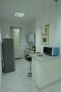 a white kitchen with a counter and a refrigerator at Park Lane Central Sarajevo in Sarajevo