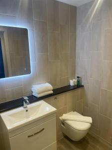 a bathroom with a toilet and a sink and a mirror at Luxurious 1 Bed - CITY VIEW in Liverpool