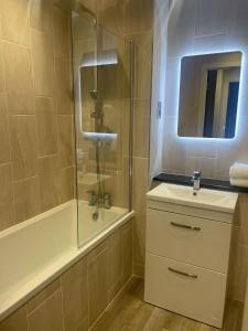 a bathroom with a shower and a sink and a tub at Luxurious 1 Bed - CITY VIEW in Liverpool