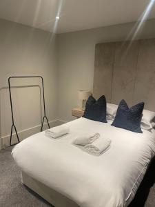 a bedroom with a large white bed with blue pillows at Luxurious 1 Bed - CITY VIEW in Liverpool