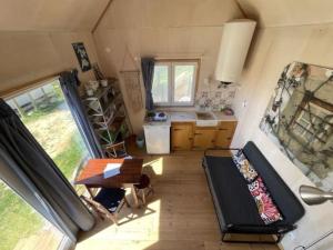 an interior view of a tiny house with a table and a kitchen at Da Silva Surfcamp, Tiny House Luna in Lourinhã