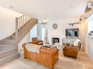 a living room with a couch and a staircase at The Ostlers Cottage in Sleaford