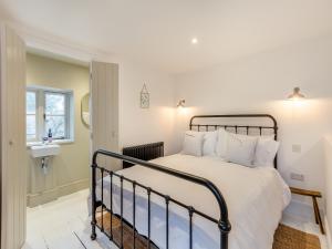 1 dormitorio con 1 cama y lavamanos en una habitación en The Ostlers Cottage, en Sleaford