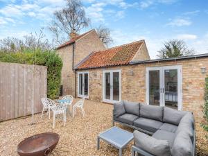 un patio con sofá, sillas y mesa en The Ostlers Cottage, en Sleaford