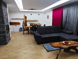 a living room with a black couch and a table at Chalety Bystrá in Bystrá