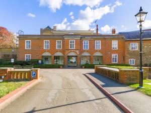 ein großes Backsteingebäude mit Straßenbeleuchtung davor in der Unterkunft Hitchin Priory Hotel in Hitchin