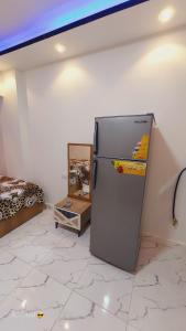 een koelkast in de hoek van een kamer bij One rela state in Zes oktober (stad)