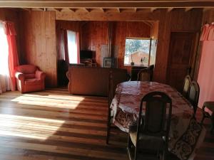 a bedroom with a bed and a chair in a room at Cabañas Los Canelos Hermosa granja en Pucón in Pucón