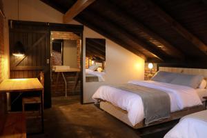 a bedroom with a bed and a table and a mirror at Chalé Monte Sião in Urubici