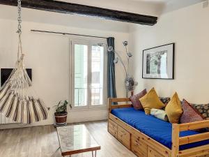 ein Wohnzimmer mit einem blauen Sofa und einem Fenster in der Unterkunft Hyper Centre Vieux Port - Loft - Les Frères de la Loc' in Marseille