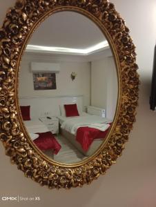 einen Spiegel, der ein Schlafzimmer mit einem Bett reflektiert in der Unterkunft ÇARŞI HOTEL&CAFE in Trabzon