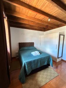 a bedroom with a bed with a green blanket at Apartamentos Dumont in Monte Verde