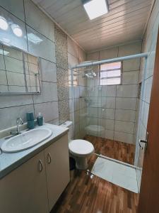 a bathroom with a toilet and a sink and a shower at Apartamentos Dumont in Monte Verde