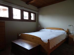 1 dormitorio con 1 cama de madera y 2 ventanas en Apartament vista Viladrau, en Viladrau