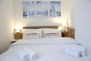a bed with white sheets and pillows in a bedroom at GreenMont Jahorina in Jahorina