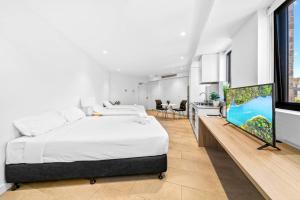 um quarto com uma cama e uma televisão de ecrã plano em Lovely Studio apartments in Strathfield CBD em Sydney