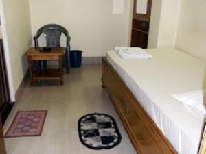 a room with a bed and a chair and a table at Hotel Chancellor,Bhubaneswar in Bhubaneshwar