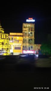 a building with a neon sign on top of it at night at Hotel Chancellor,Bhubaneswar in Bhubaneshwar