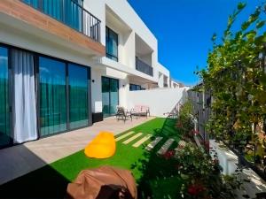 a backyard with a yellow cone on the grass at Luxury Villas with Beach Access by VB Homes in Ras al Khaimah