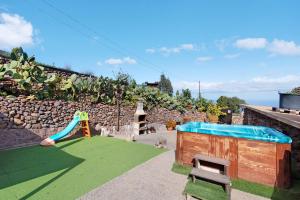a play area with a slide and a playground at Hogar vacacional Maya in Santa Maria de Guia de Gran Canaria