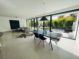uma sala de jantar com uma mesa e cadeiras numa sala de estar em seenahe Design-Ferienwohnung Loft Aquamarin em Überlingen