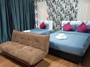 a bedroom with two beds with red pillows and a chair at Khokeng Room in Ban Ko