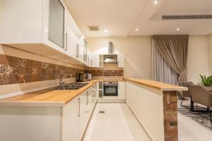 uma cozinha com armários brancos e uma bancada em Nuzul R145 - Elegant Apartment em Riyadh