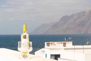 a bottle of wine sitting on top of a building near the ocean at Casa Bianca Caleta De Famara in Famara