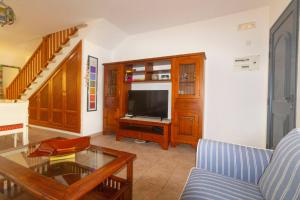 ein Wohnzimmer mit einem Sofa und einem TV in der Unterkunft Casa Bianca Caleta De Famara in Famara