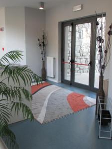 Habitación con cama y puerta con alfombra en Ostello La Mine, en Cogne
