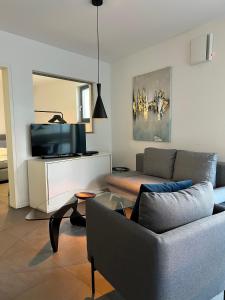 a living room with a couch and a tv at Cosmopolitan in Überlingen